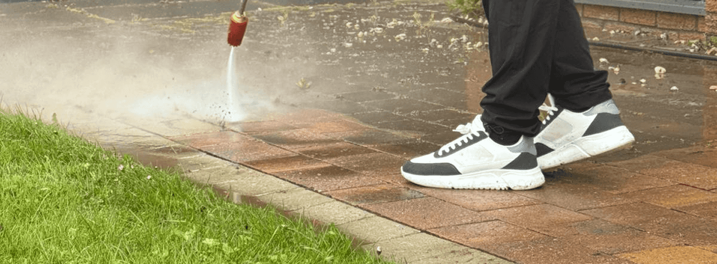 Staff member of Smart pressure washing company pressure washing a patio