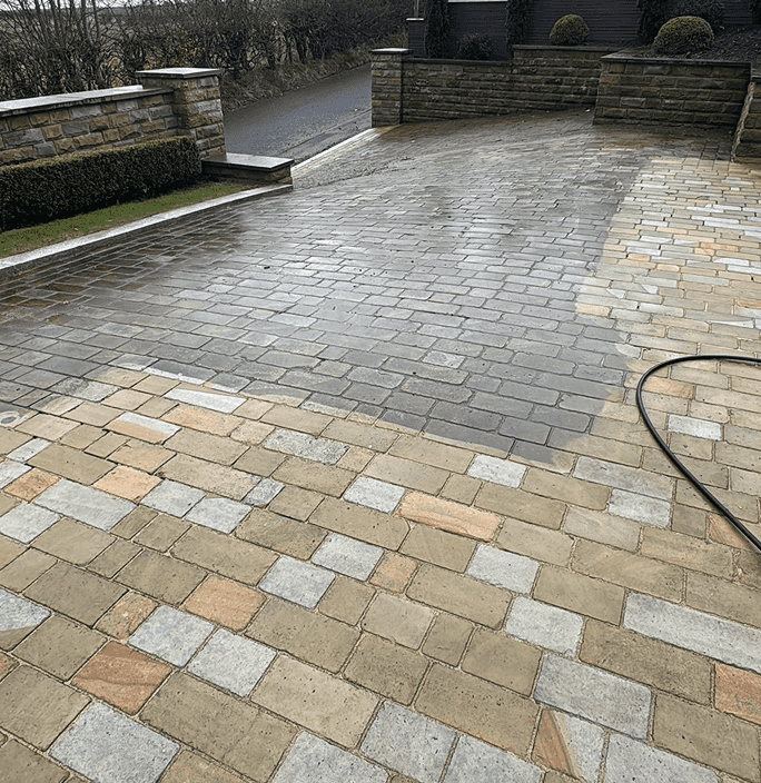A massive driveway that enters a sprawling estate all up hill after being throughly power washed and cleaned, still has the wet look