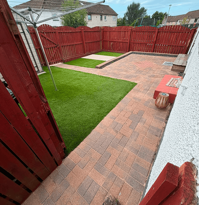 A back garden with astro turf grass but with power washed concrete red slabs in between providing a beautiful clean finish