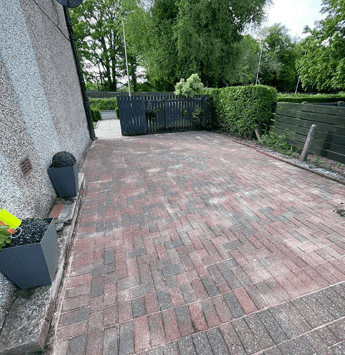 Red and mixed pattern of a driveway at the side of the house all power washed and cleaned