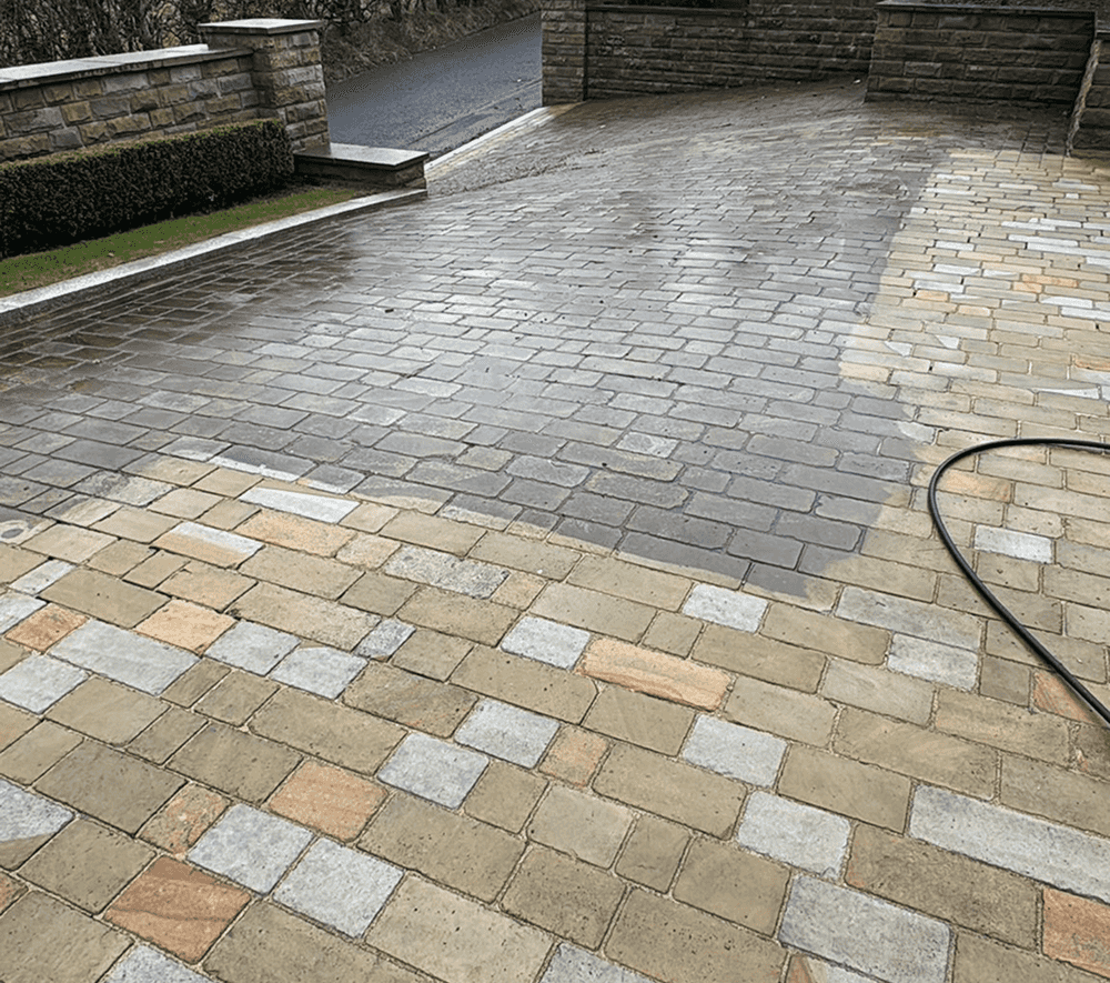 Large traditional steep hilly driveway befitting a large estate in the middle of being power washed