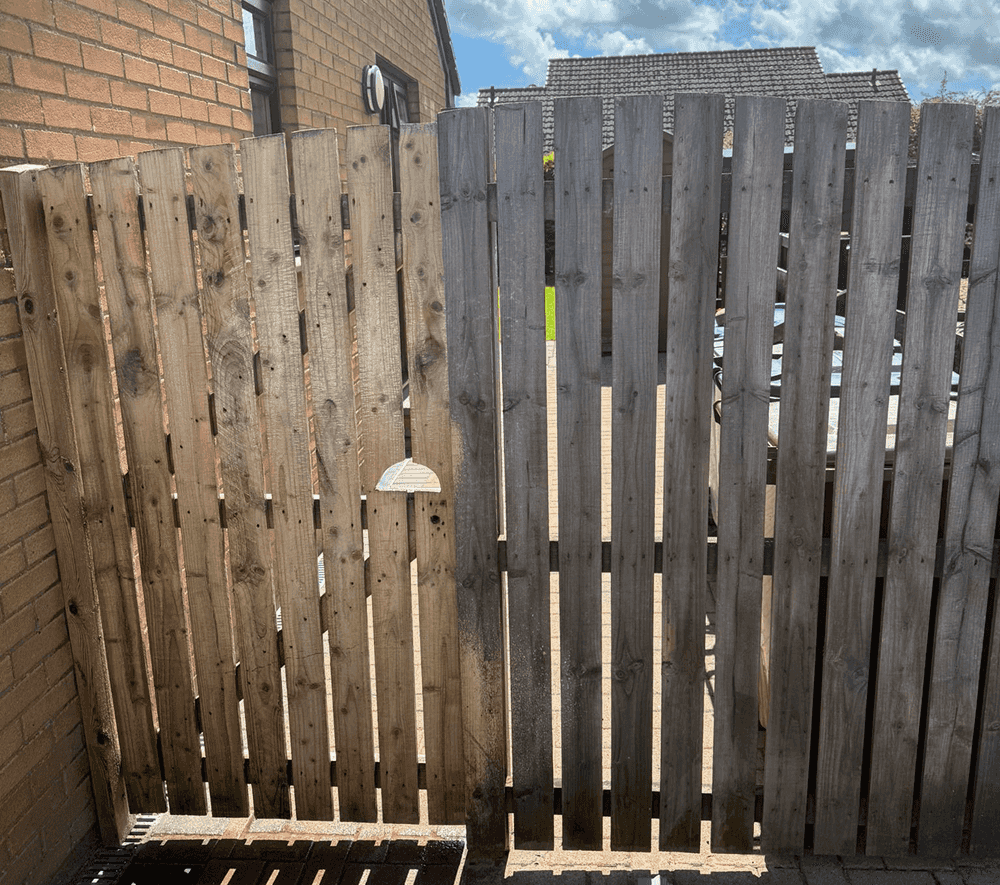 Stock image of wooden fence in the middle of being power washed